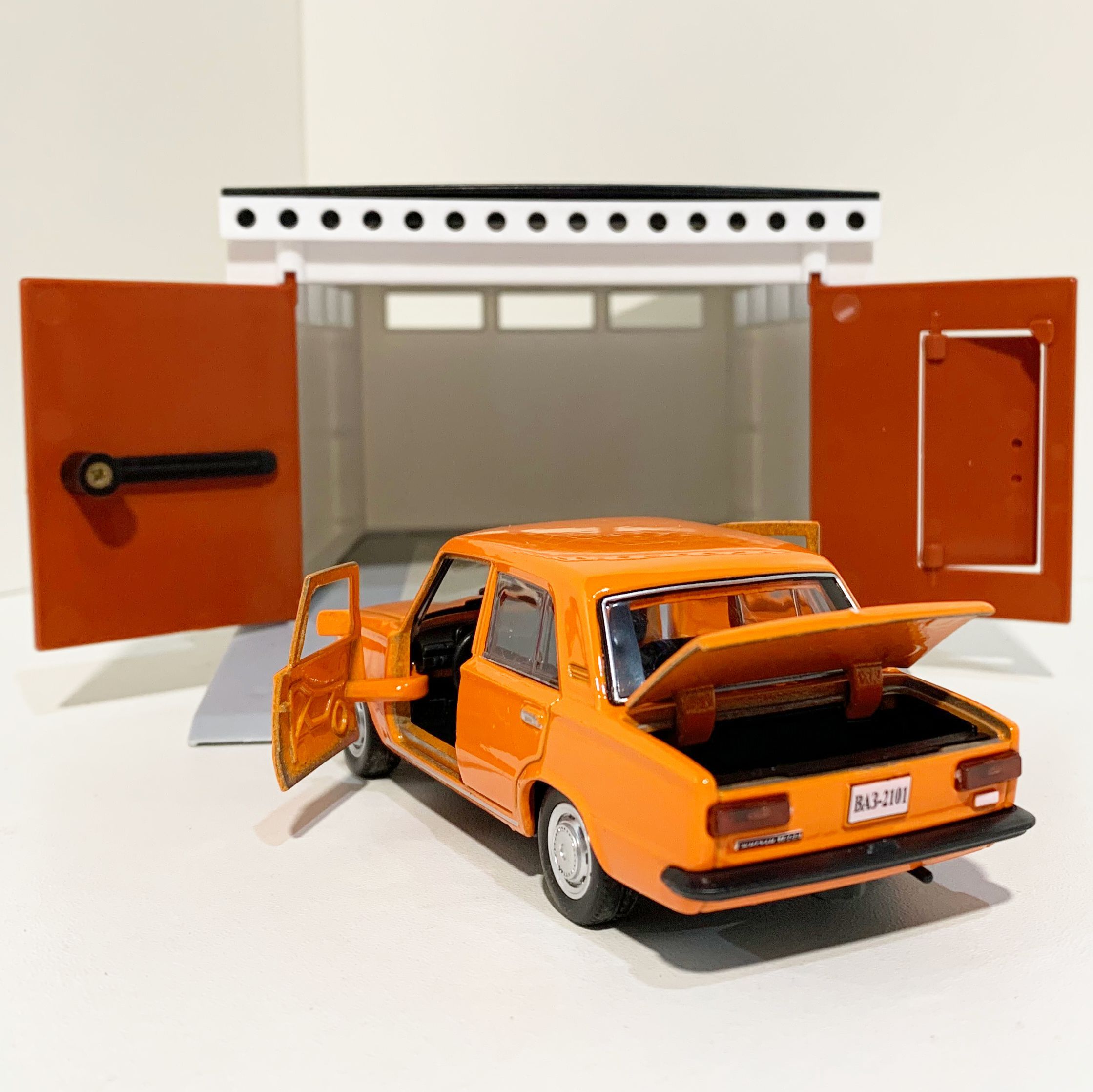 Гараж с распашными воротами и металлическая машинка 12 см модель ВАЗ 2101 инерция, 2 откр. двери и багажник - оранжевая