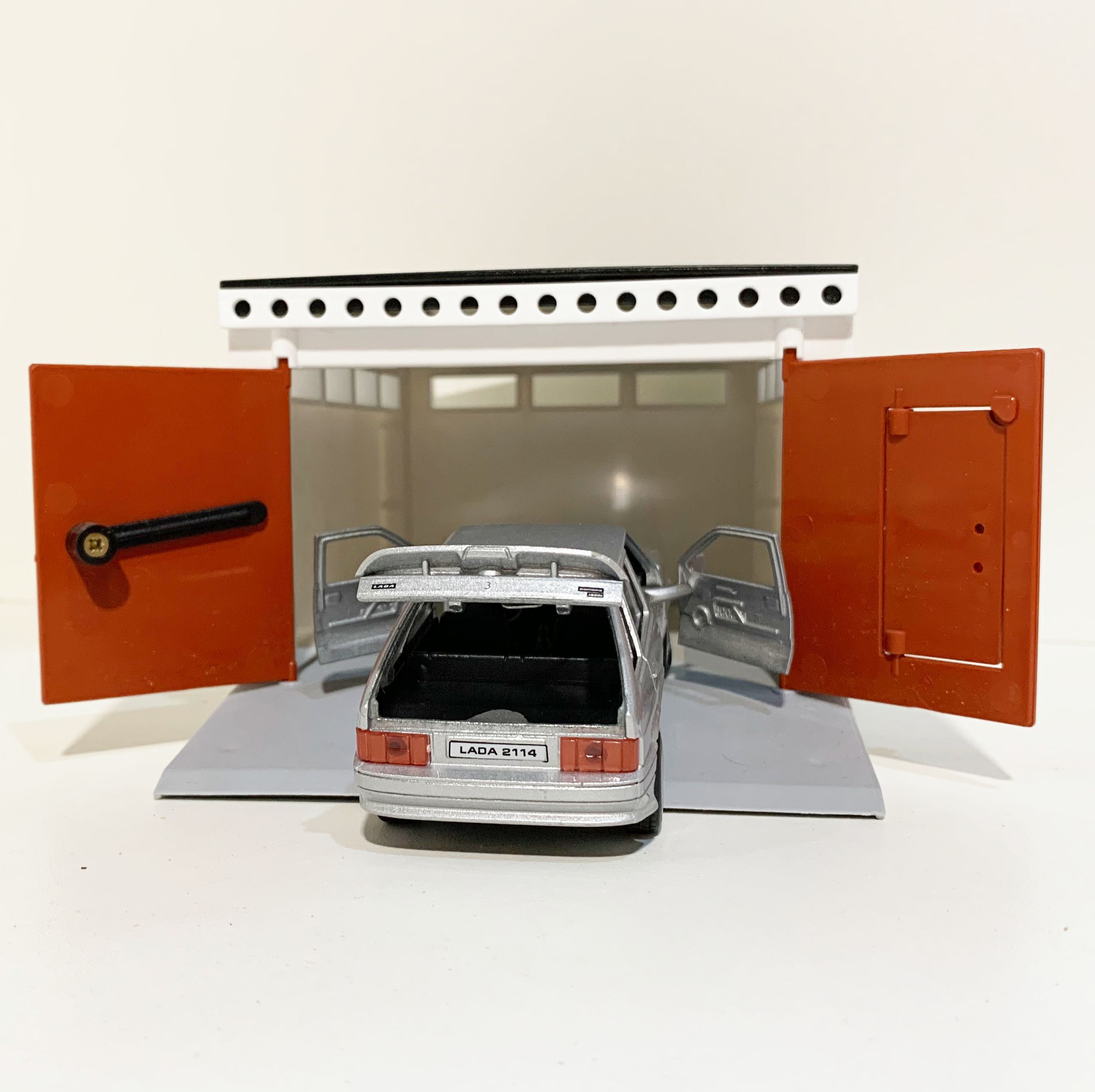 Гараж с распашными воротами и металлическая инерционная машинка ВАЗ 2114 с открывающимися дверями и багажником серебристая