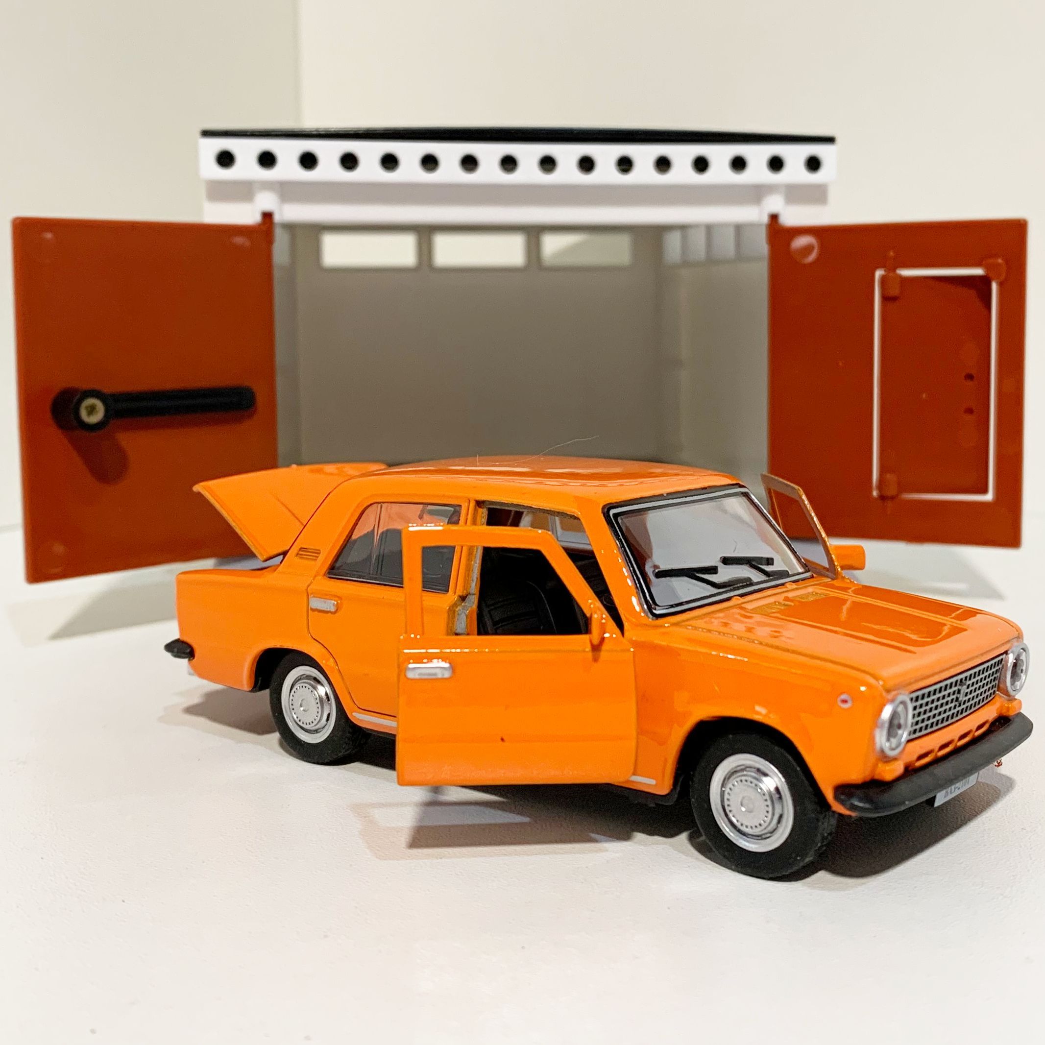 Гараж с распашными воротами и металлическая машинка 12 см модель ВАЗ 2101 инерция, 2 откр. двери и багажник - оранжевая