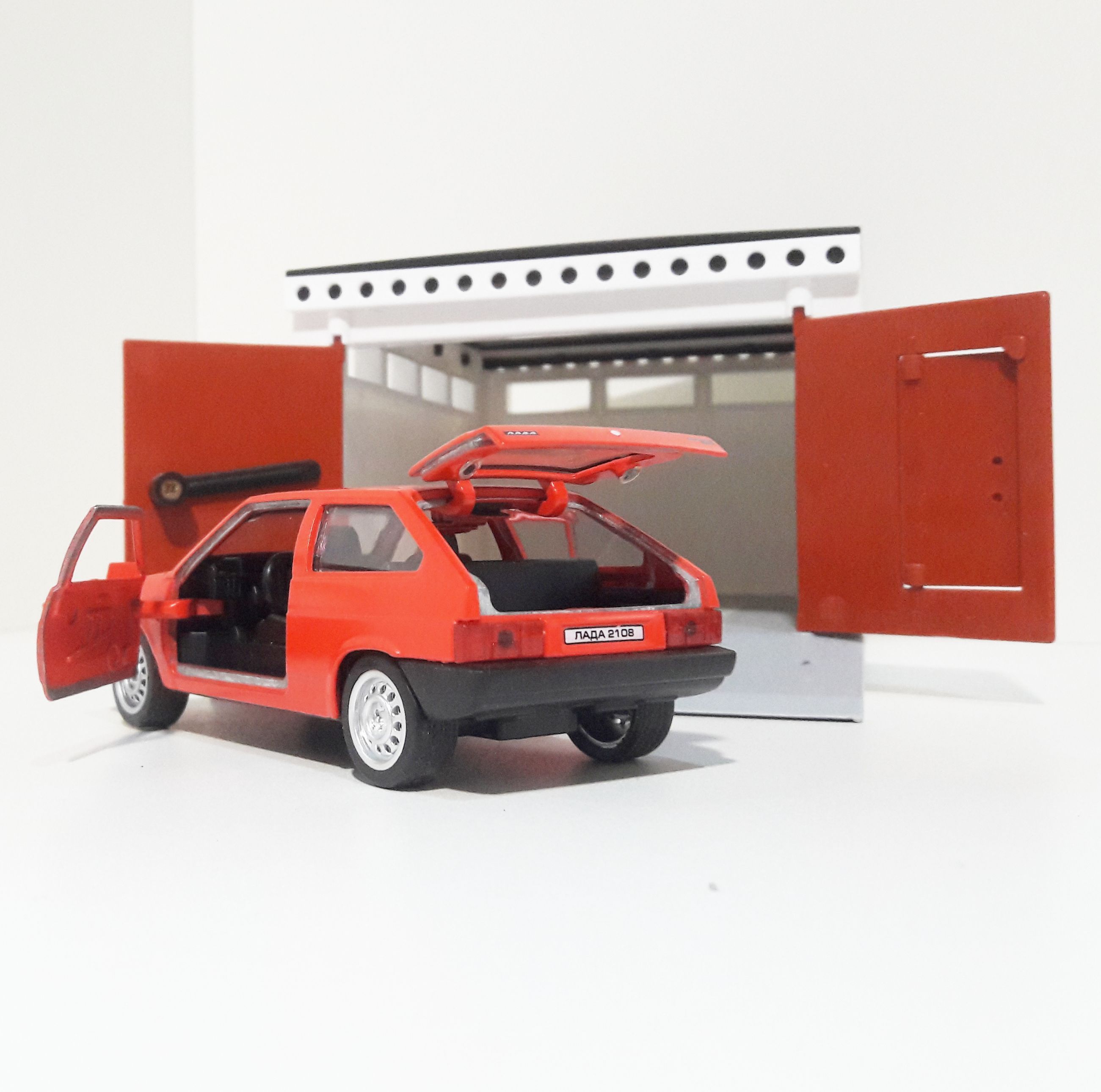 Гараж разборный и металлическая машинка 12 см с инерционным механизмом и открывающимися дверями ярко-красная