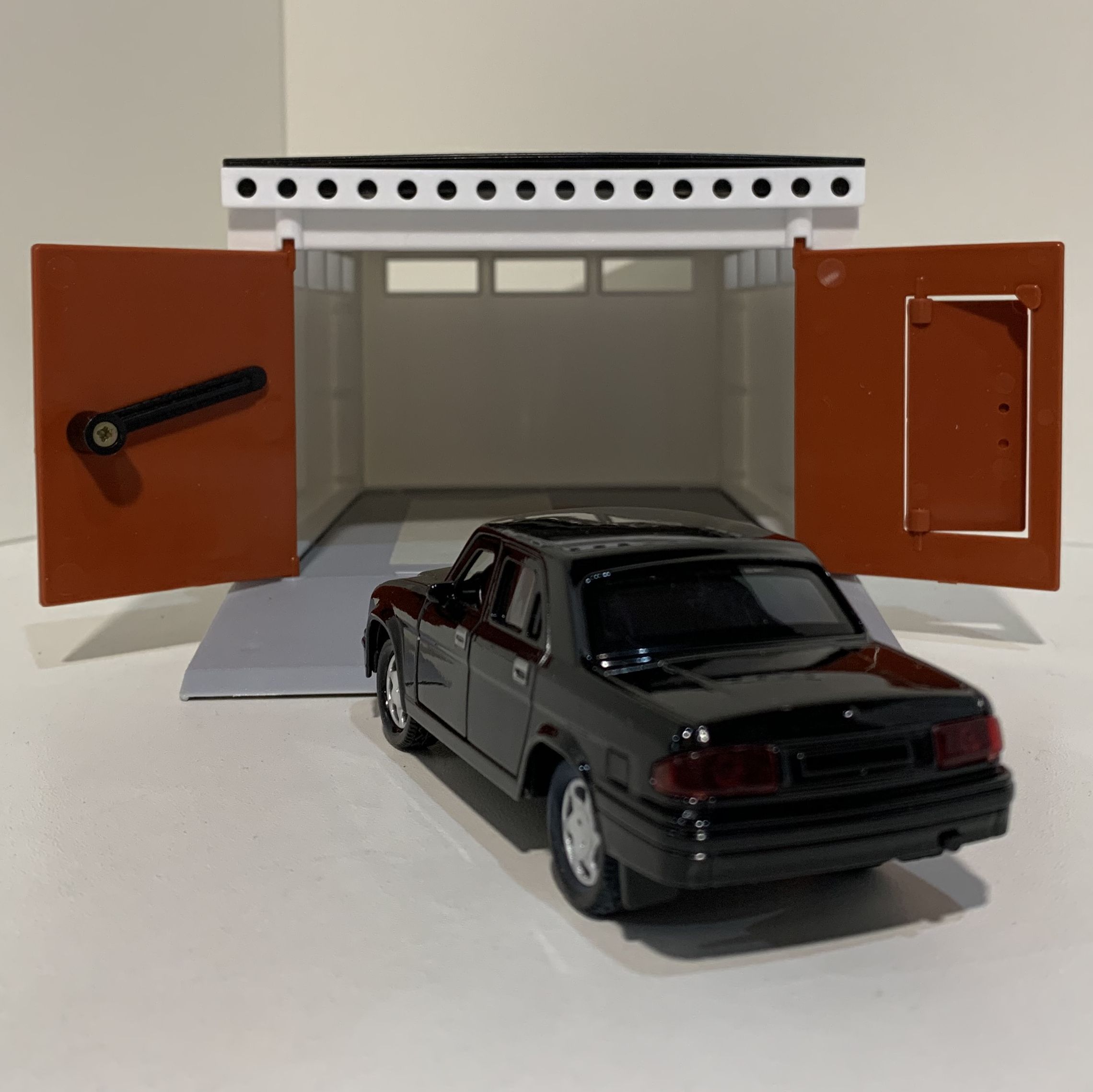 Гараж с распашными воротами и металлическая инерционная машинка Волга 3110 с 2-мя открывающимися дверями 12 см - черная