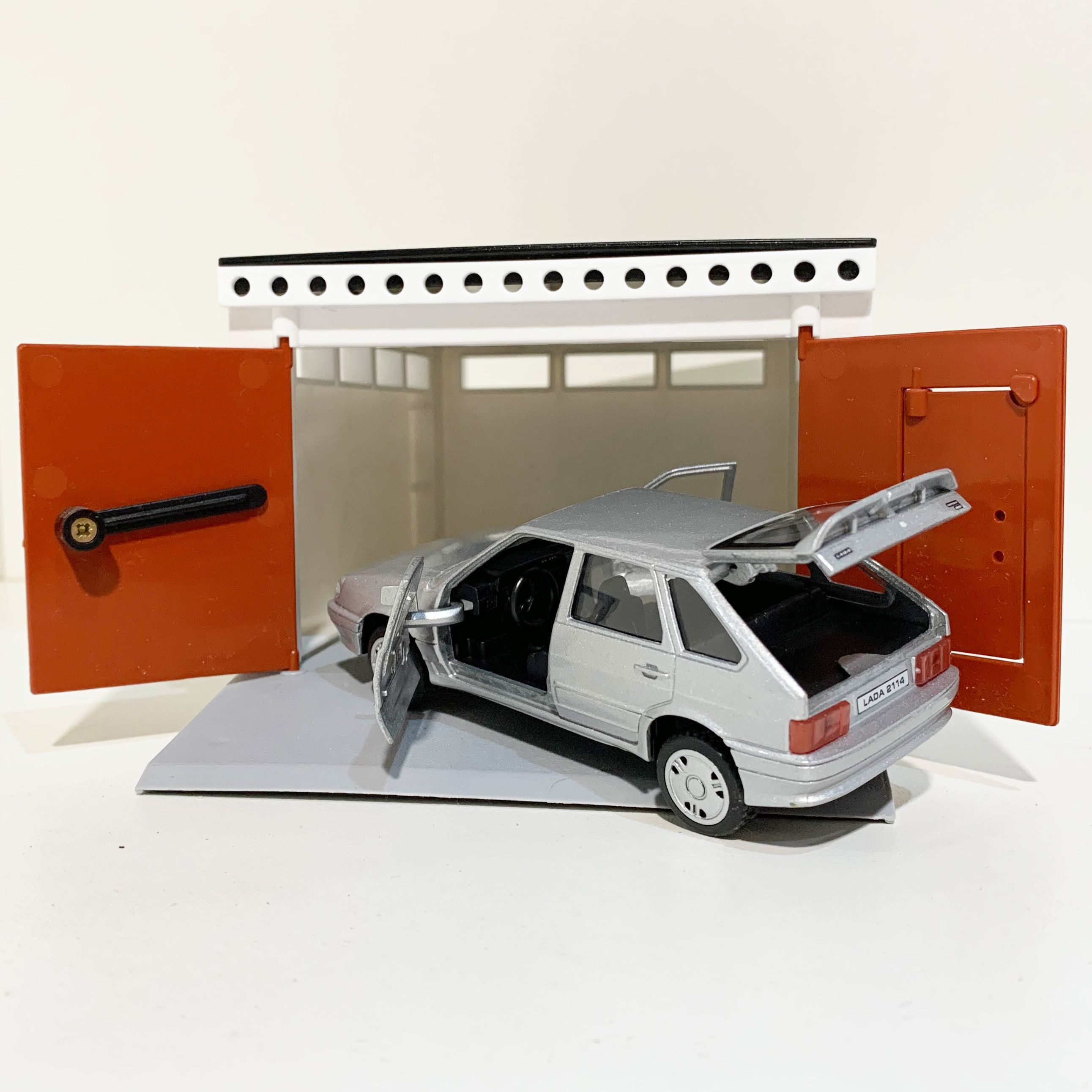 Гараж с распашными воротами и металлическая инерционная машинка ВАЗ 2114 с открывающимися дверями и багажником серебристая