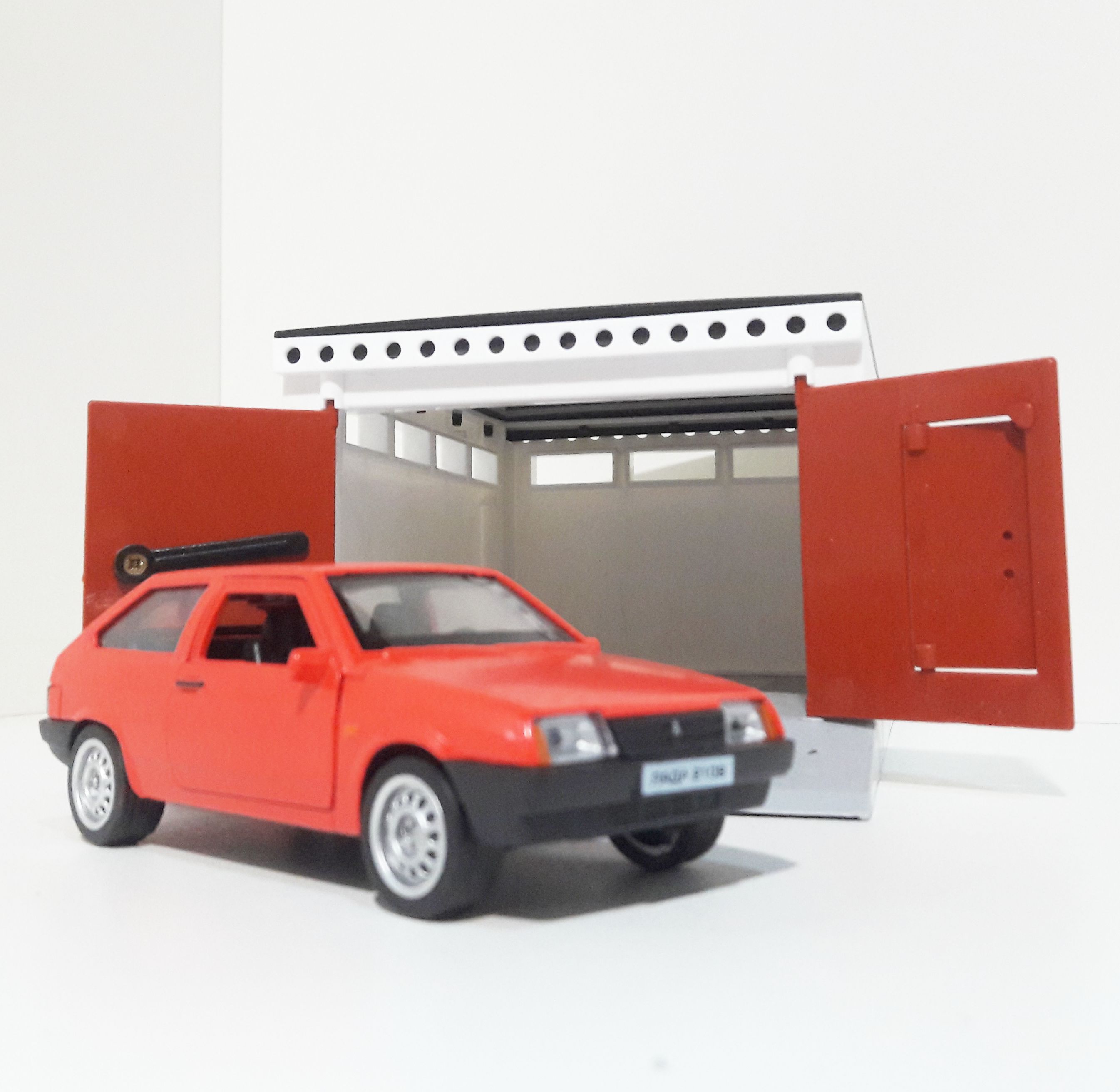 Гараж разборный и металлическая машинка 12 см с инерционным механизмом и открывающимися дверями ярко-красная